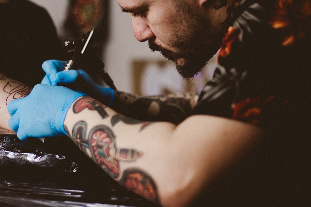 artist applying a small forearm tattoo 