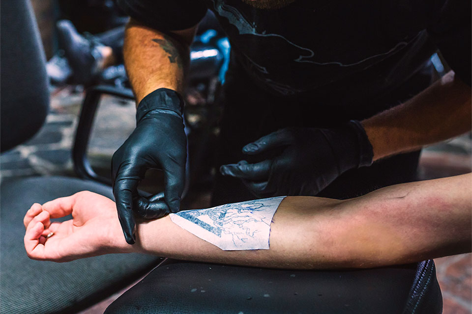 preparing_skin tattoo artist showing how to use tattoo transfer paper