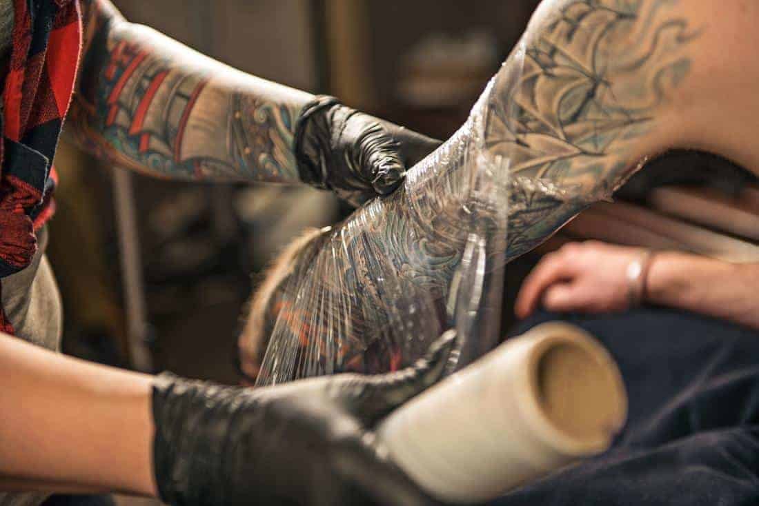 Tattoo Aftercare wrapping a new tattoo in a tattoo parlor