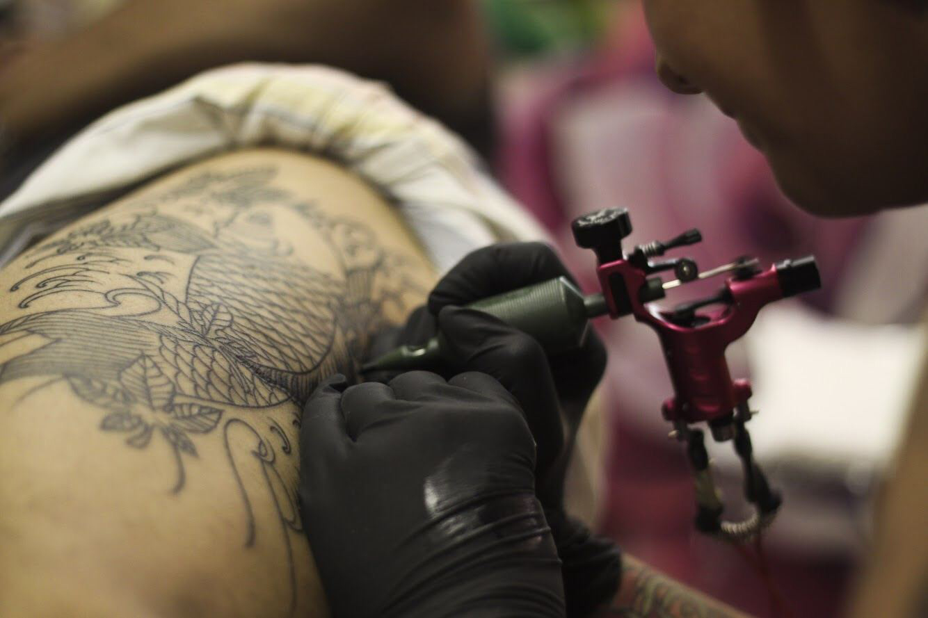 tattoo-artist-tattooing-fish-tattoo-design-1