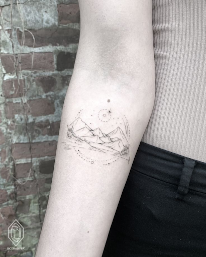 Fine line tattoo of mountains