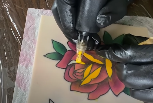 red rose tattoo on practice skin tattooing yellow ink